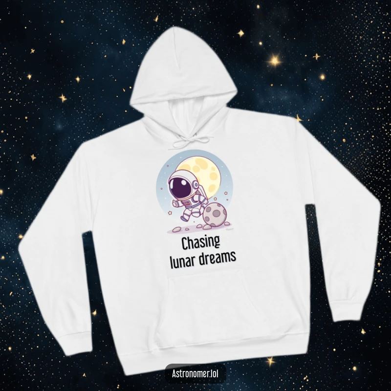 Funny hoodie featuring a cartoon astronaut playfully chasing a rolling moon rock, offering warmth and a galactic sense of fun.