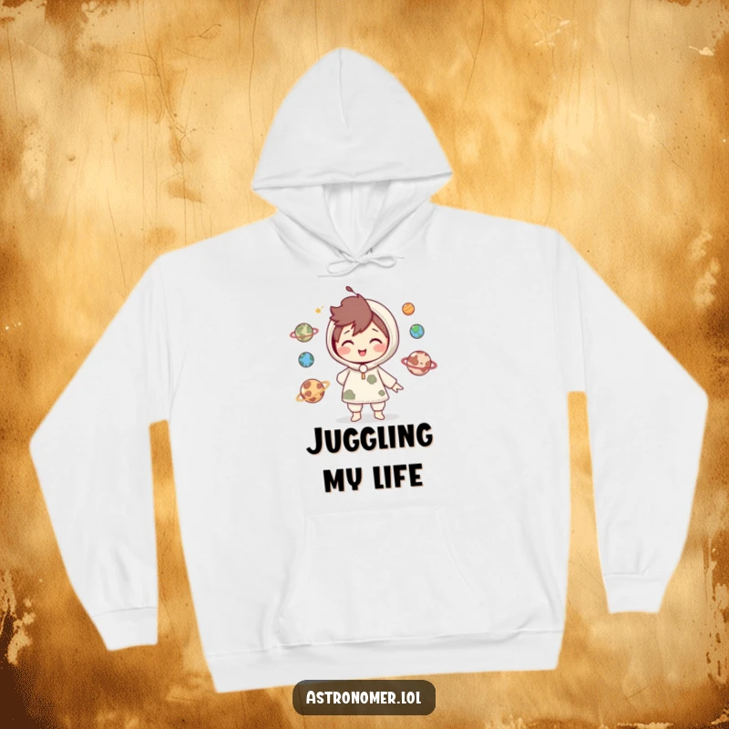 Funny Hoodie: Cute character smiles playfully while juggling miniature planets, showcasing impressive cosmic coordination and a lighthearted nature.