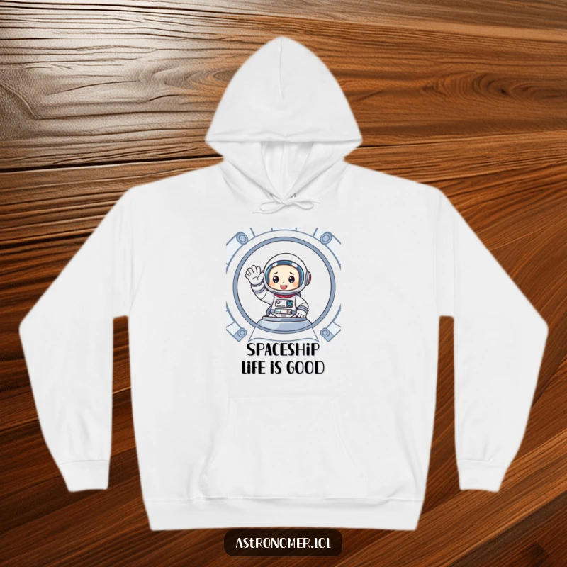 Funny hoodie featuring a cartoon astronaut enthusiastically waving from inside a spaceship, offering comfort and a friendly hello.